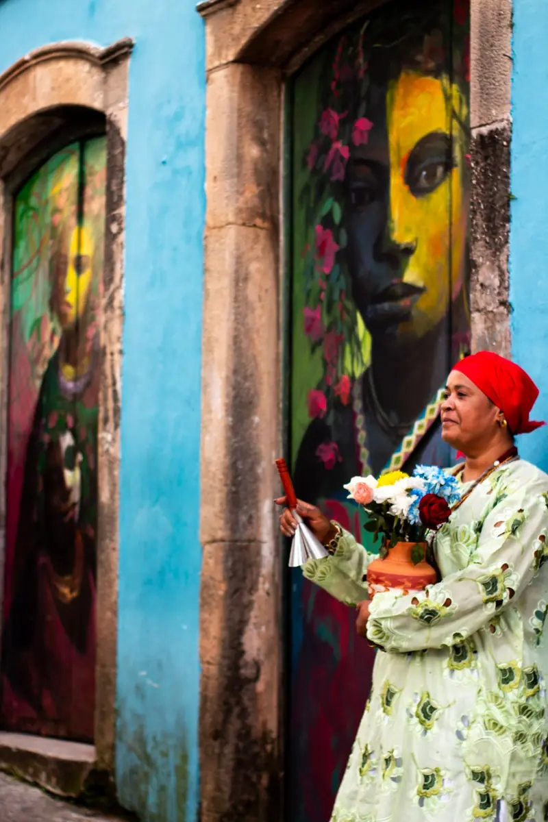 Mãe Iara com adjá diante das portas pintadas do Centro Histórico