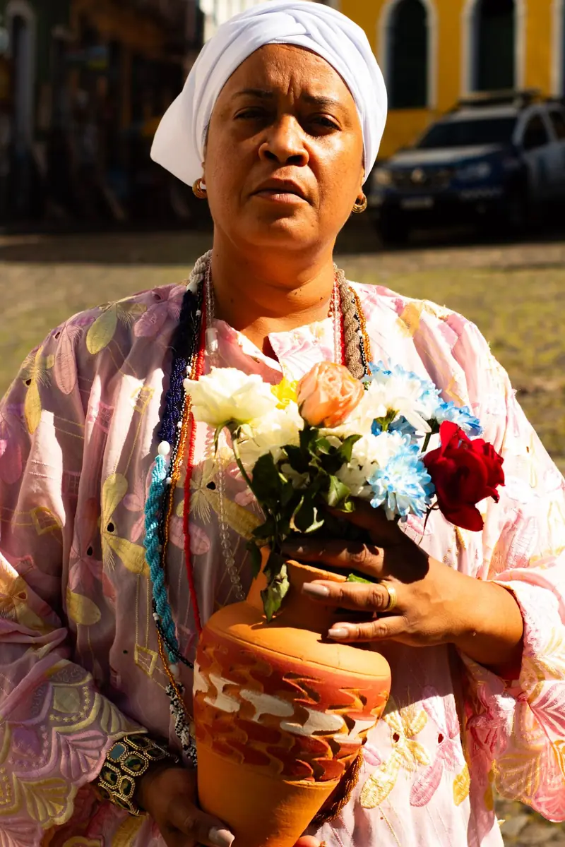 Mãe Iara segurando vaso com flores