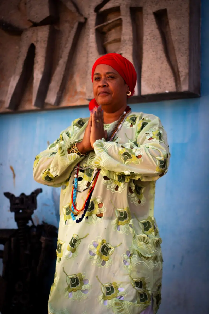 Mãe Iara de Iansã de turbante vermelho, com as mãos unidas